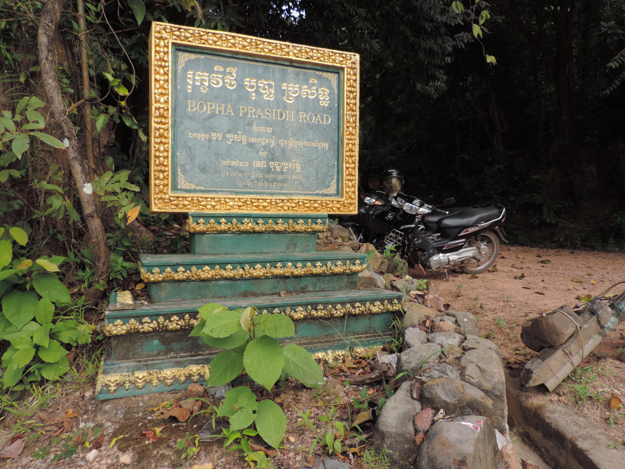Moto naast info-bord in Khmer-taal.