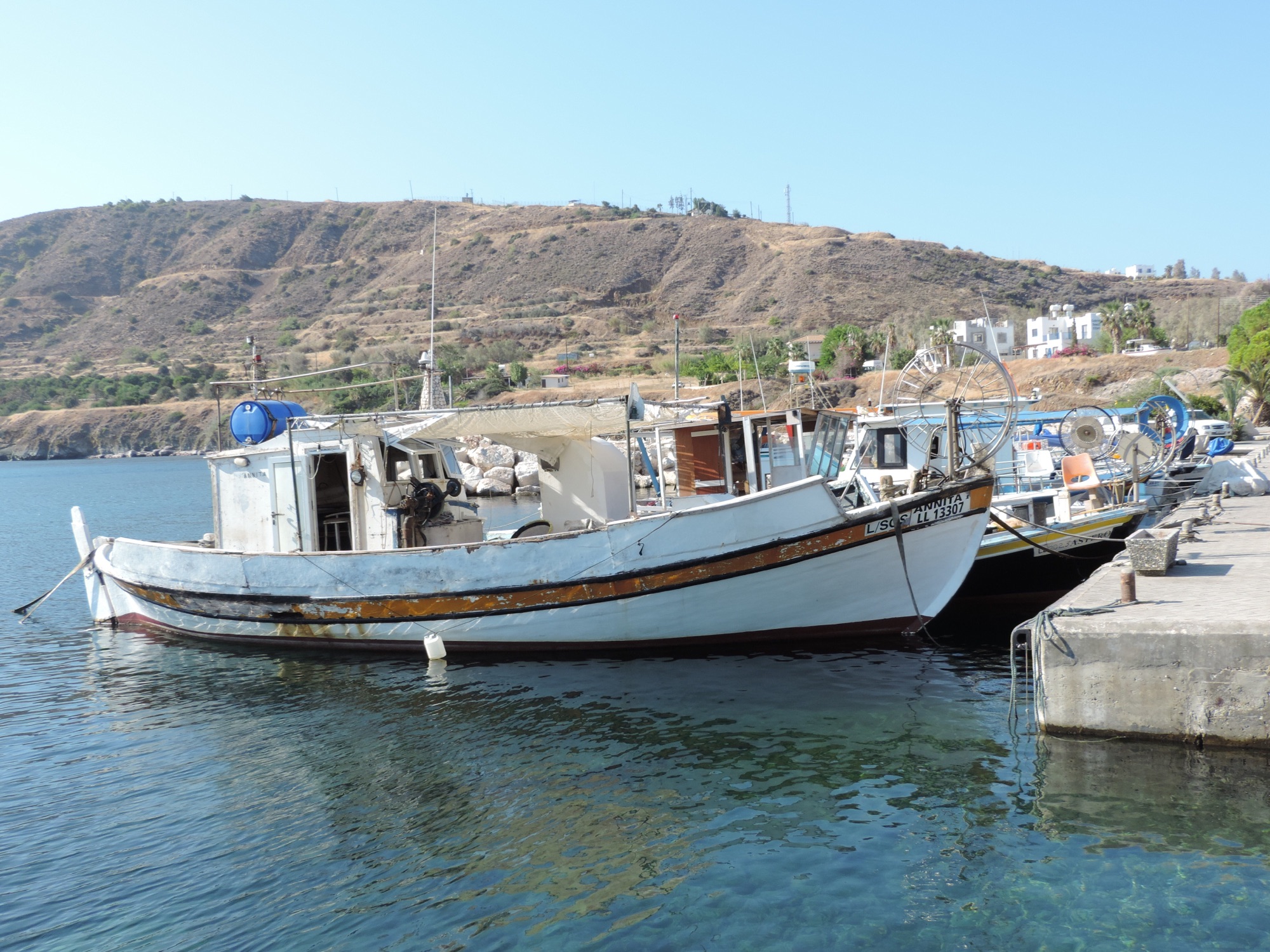 Bootjes in haventje met bergen op achtergrond. 