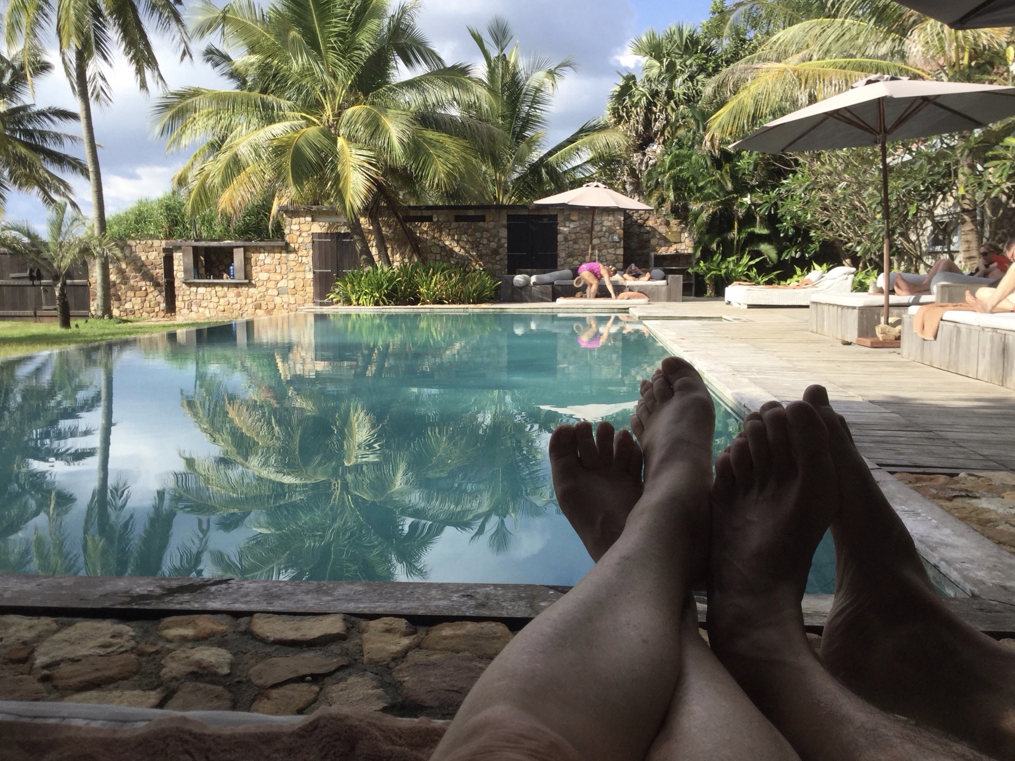 Blote voeten voor zwembad in tropische tuin. 