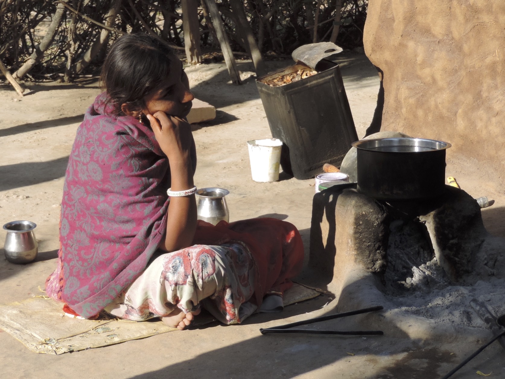 Zittend meisje voor aarden kacheltje