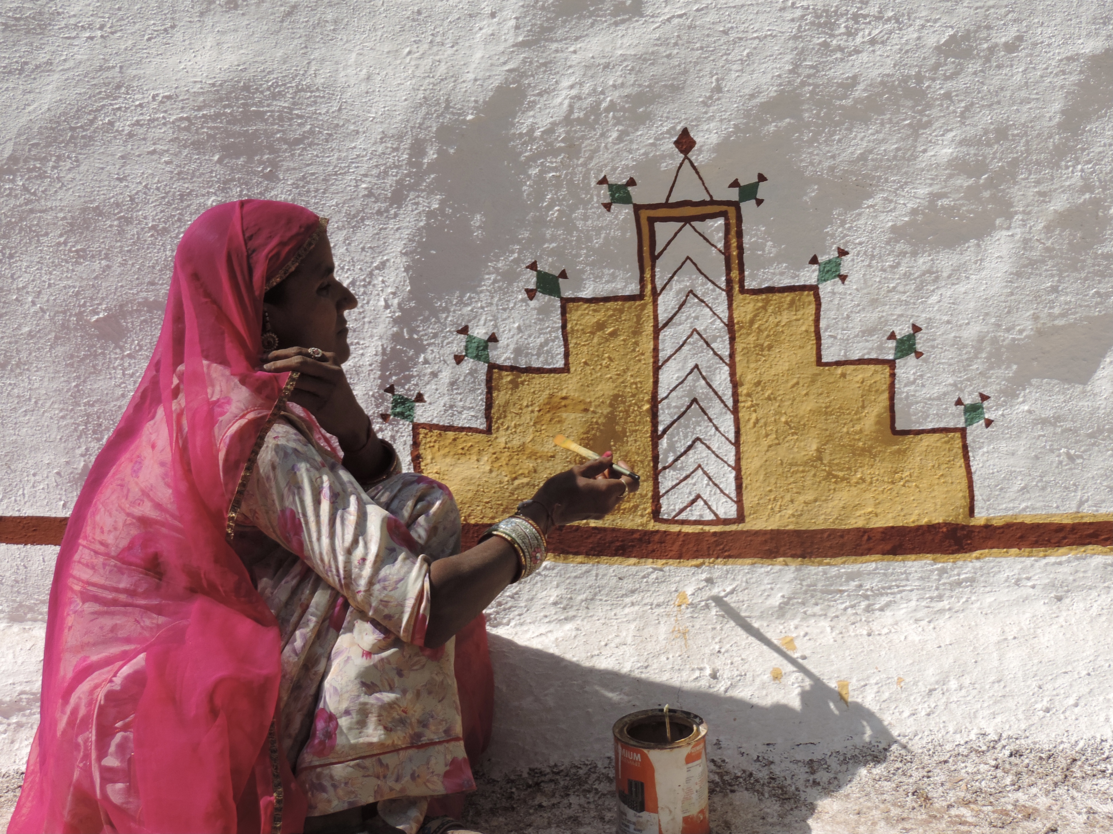 Artieste schildert muur in Shilpgram.