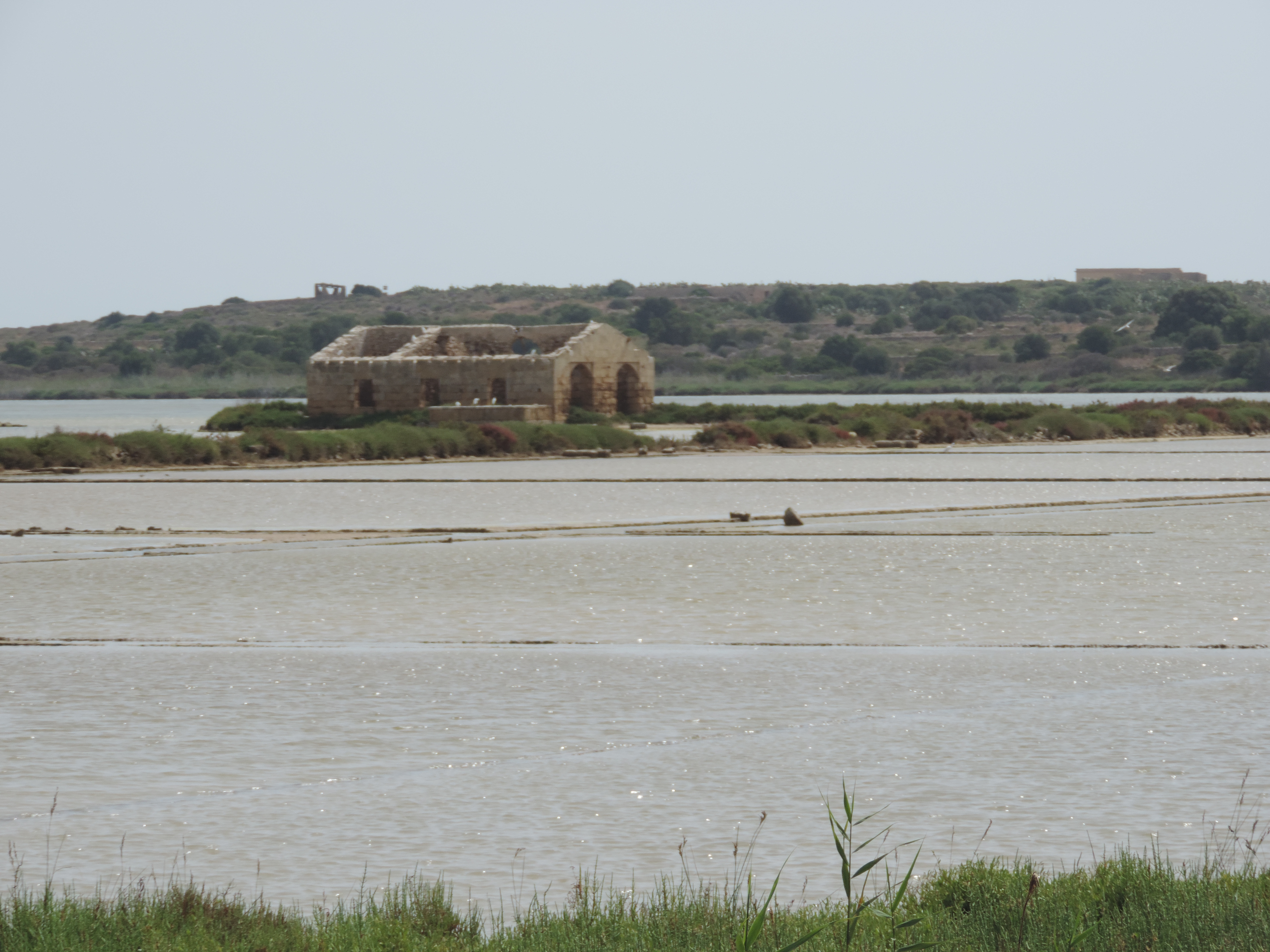 Ruïne van huis omringd door water.