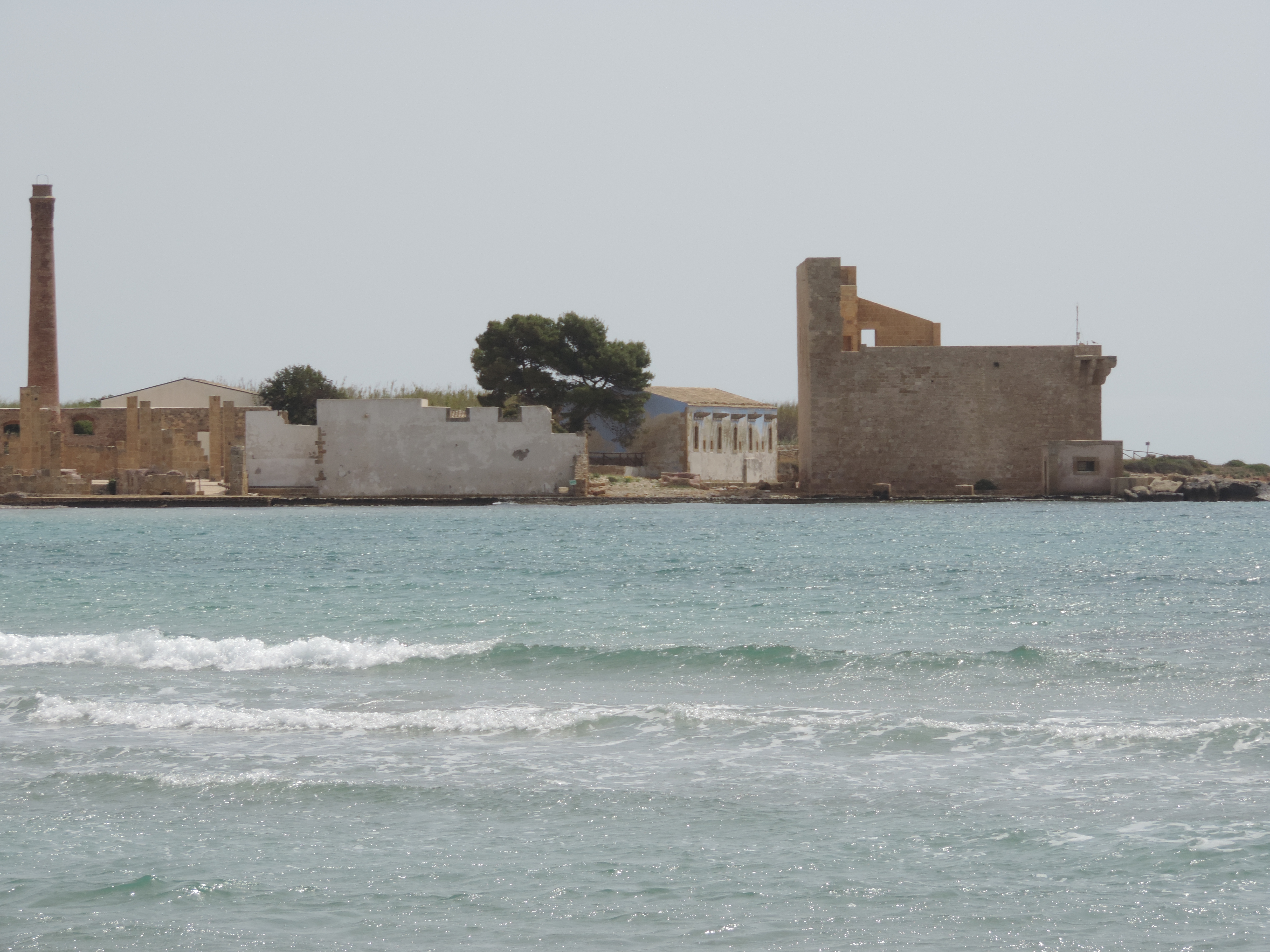 Ruïnes van tonijn verwerkingsfabriek omringd door water.