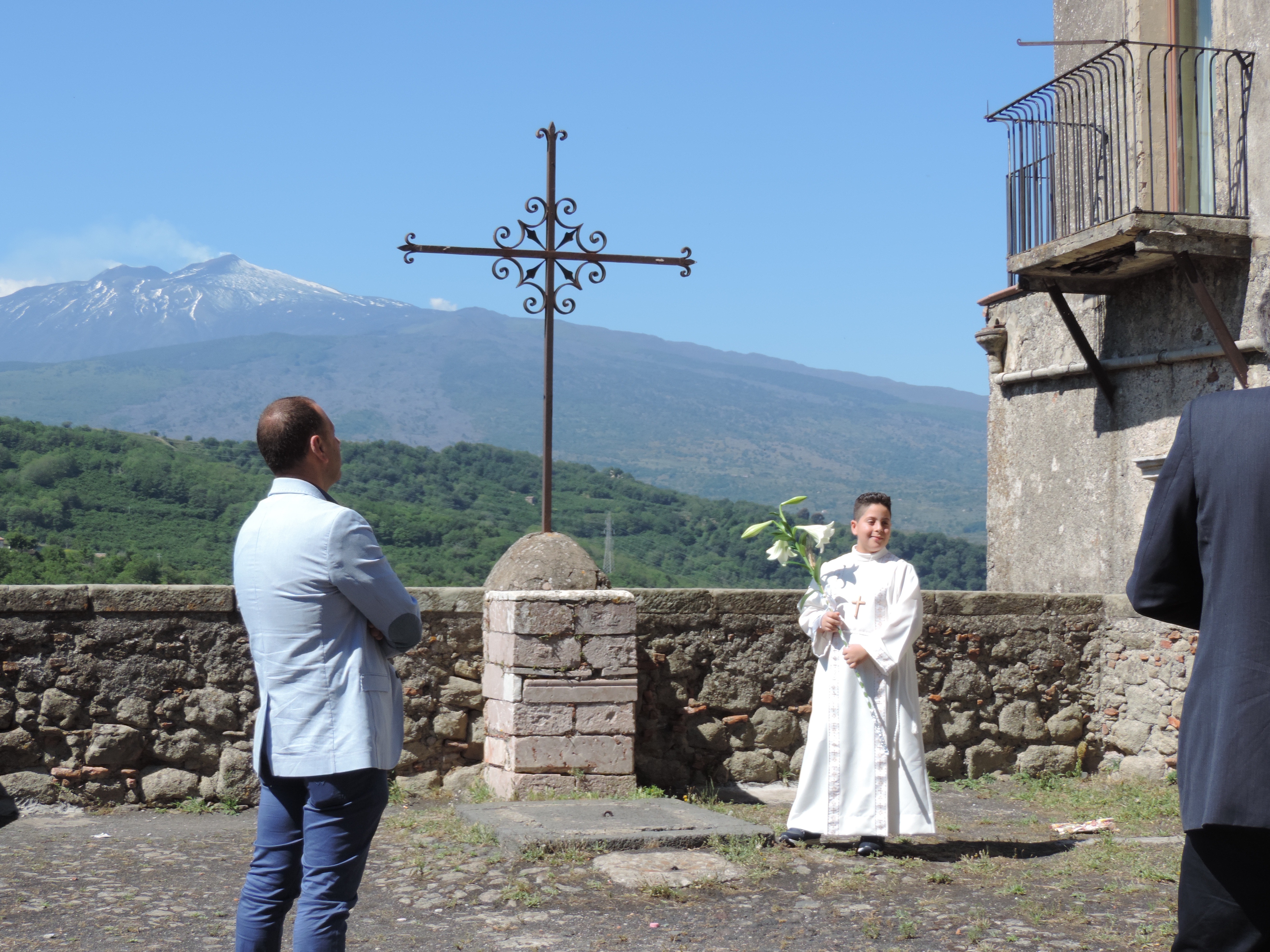 Communicant in het wit met Etna op achtergrond.
