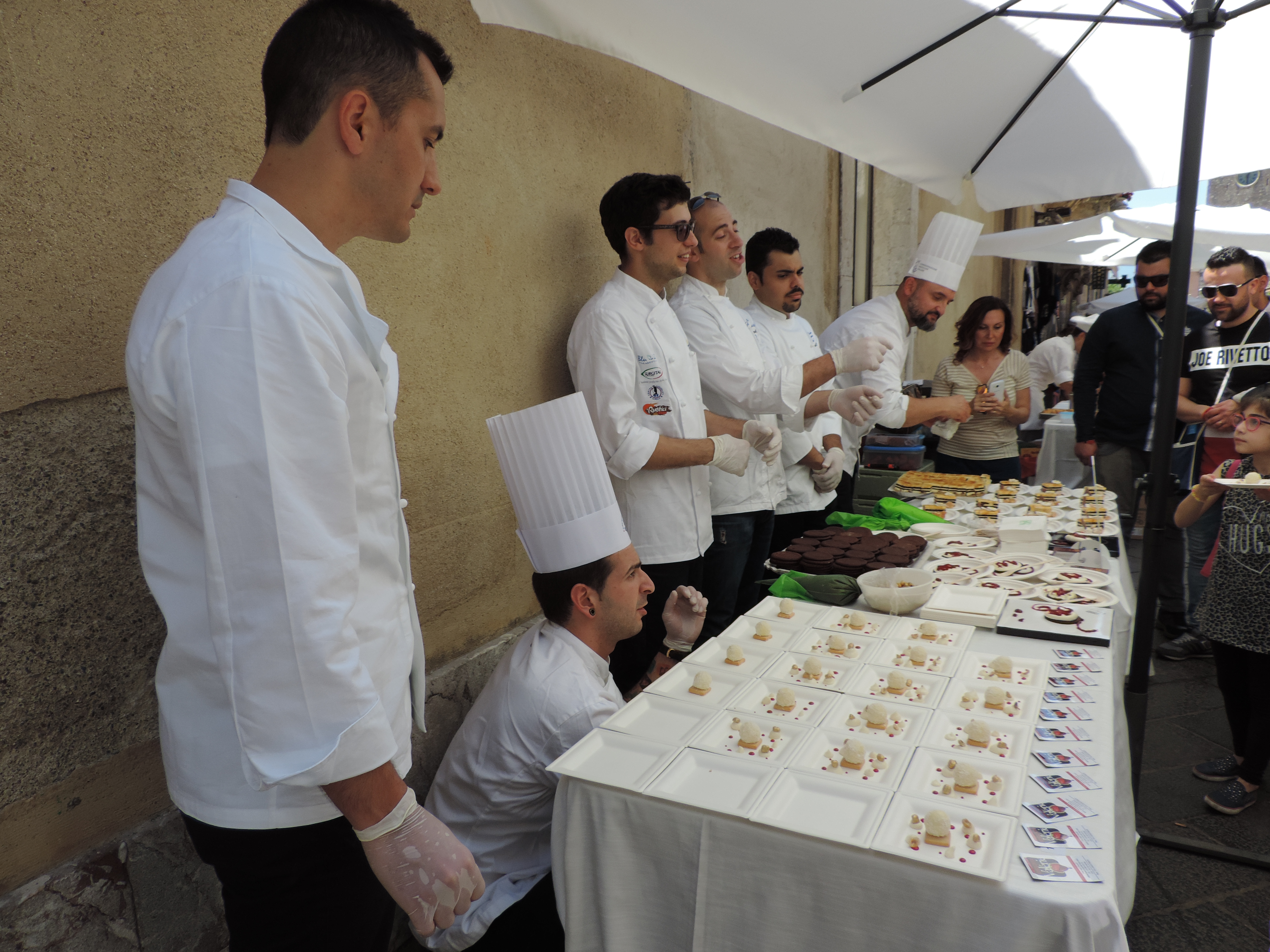 Koks met koksmutsen aan gedekte tafels.