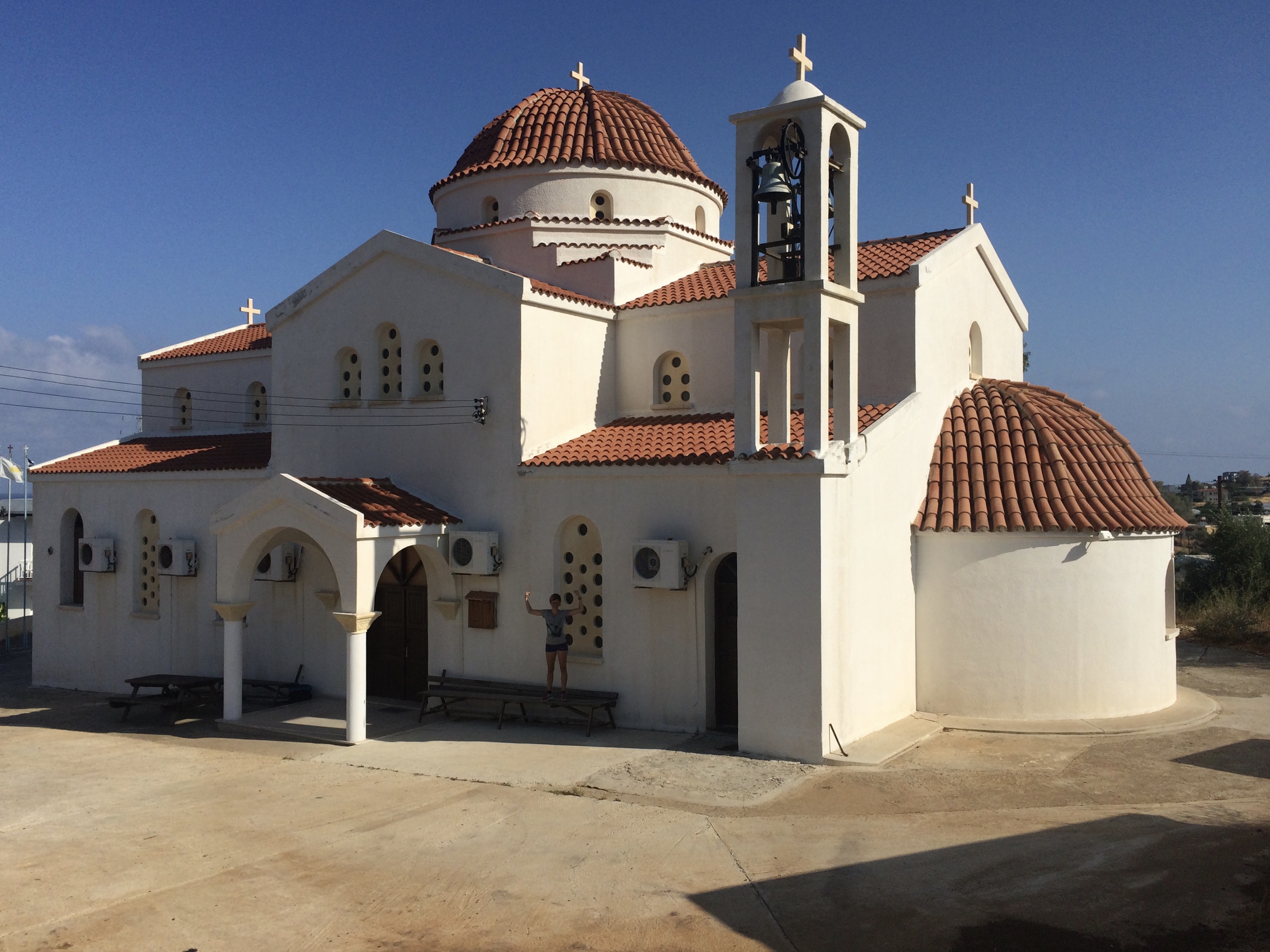 Wit, orthodox kerkje met rode koepels.