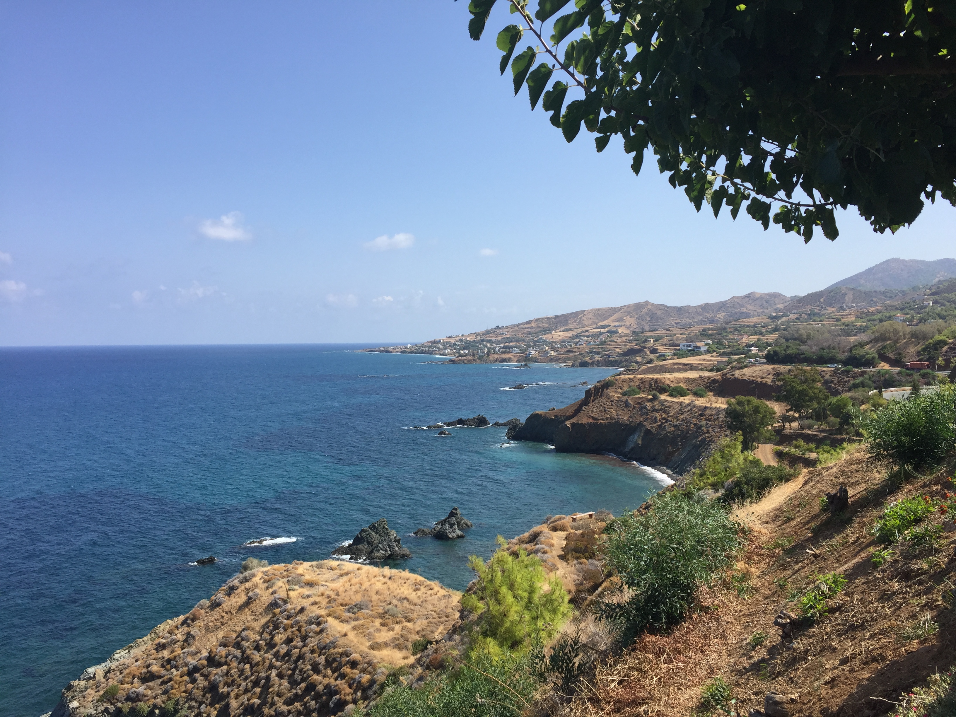 Baai met blauwe zee en bergen.