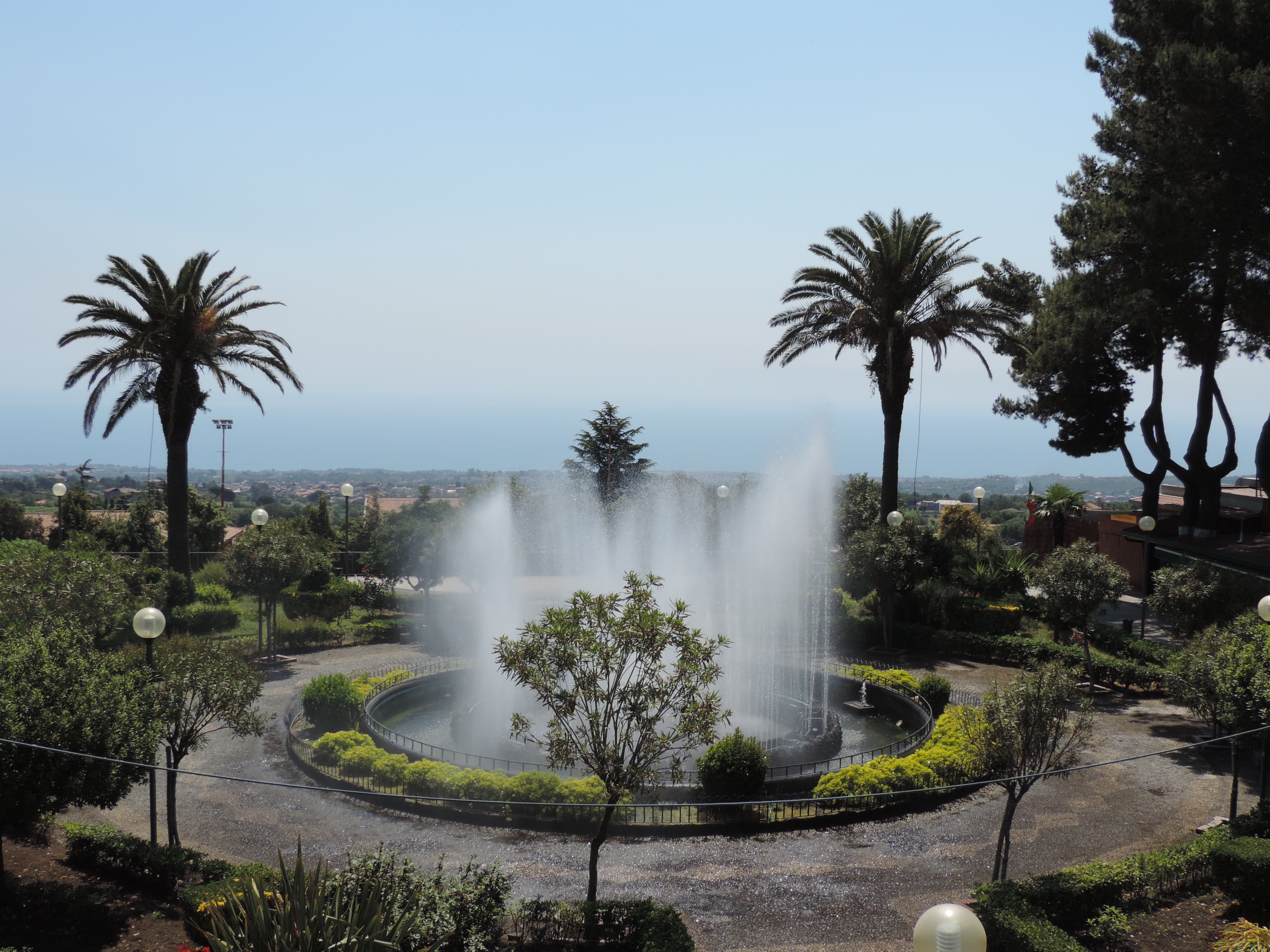 Fontein, palmbomen, zicht vanaf Zafferana.