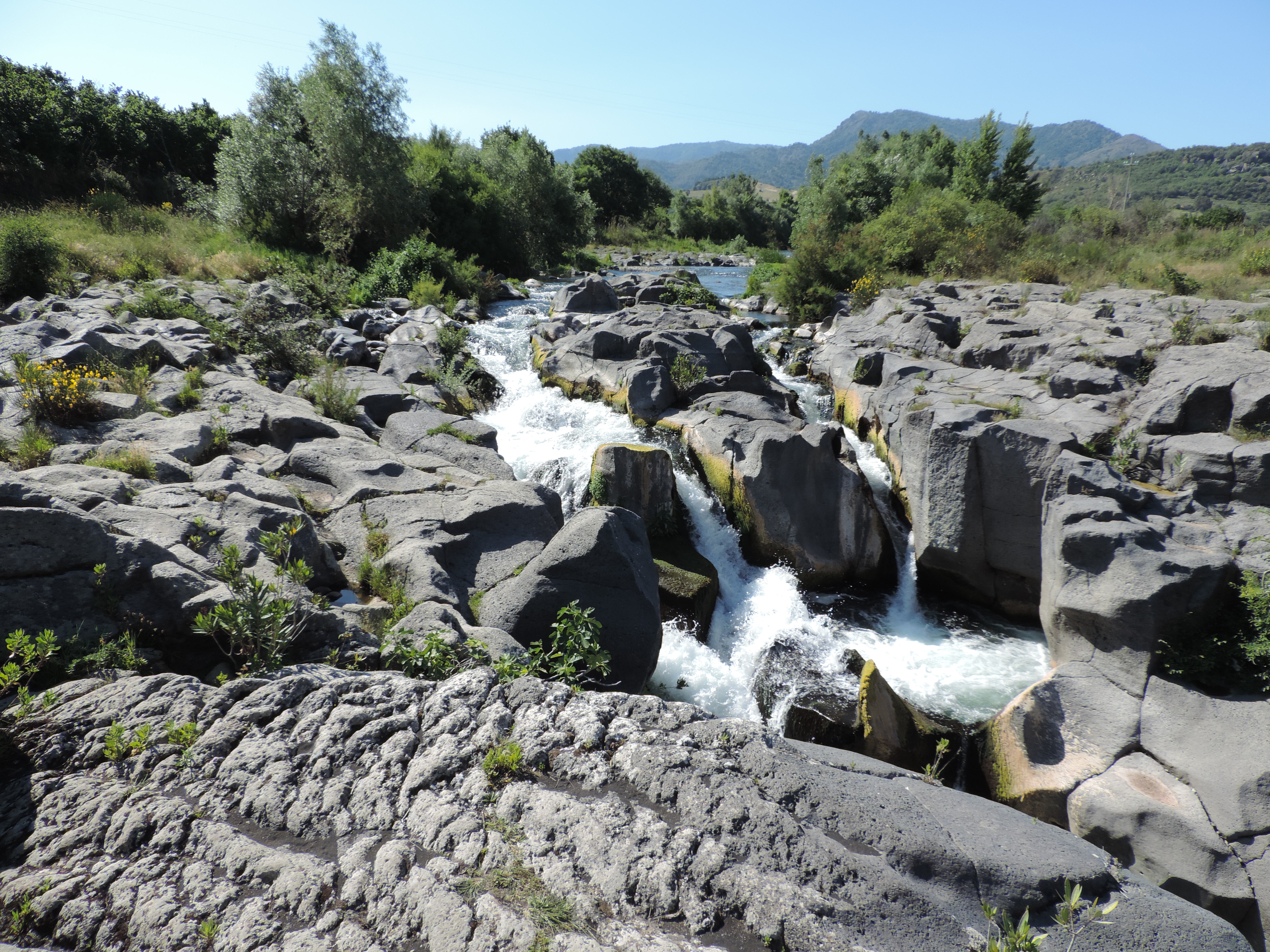 Riviertje stroomt door tussen grijze rotsen.