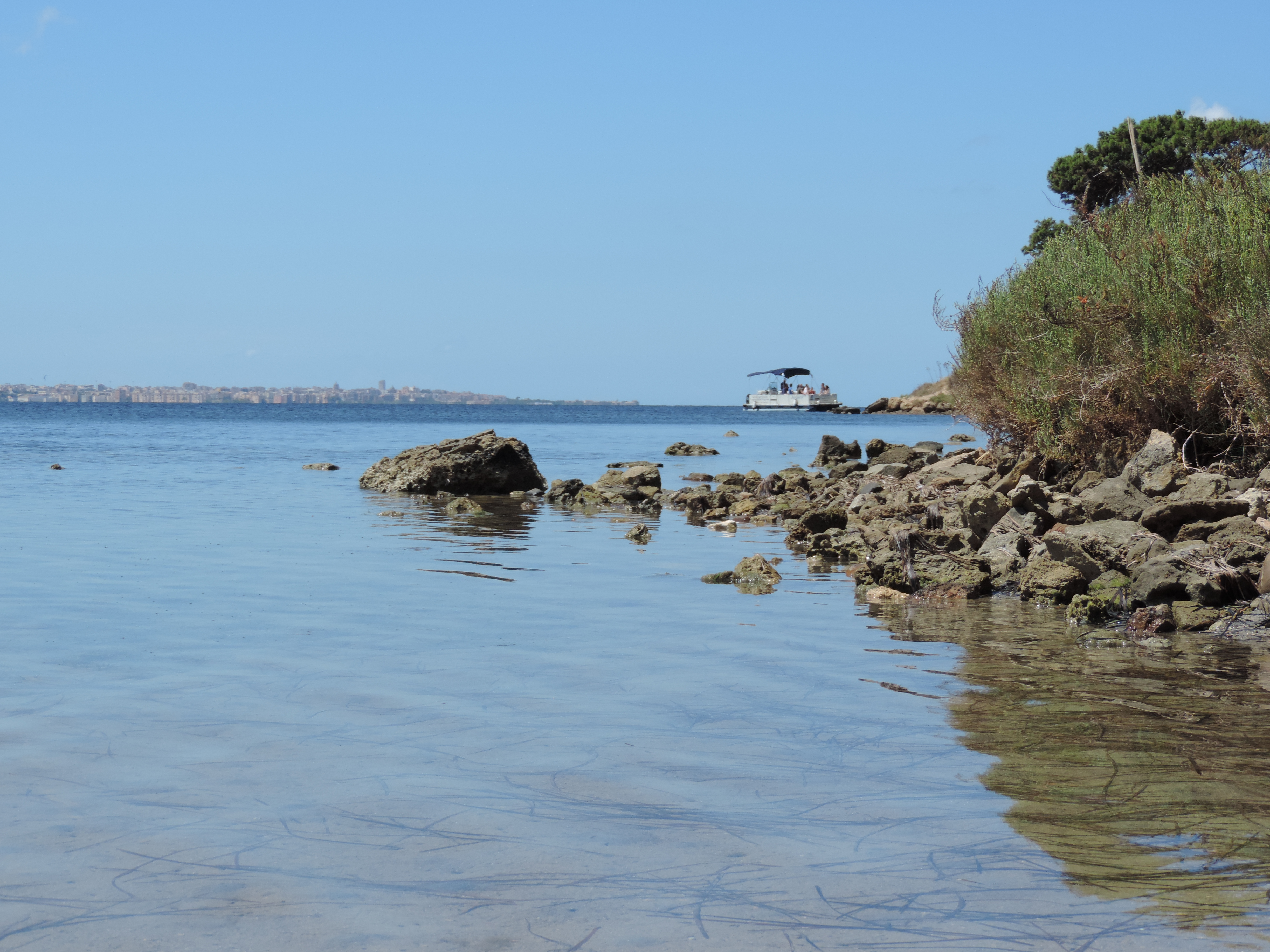 Zee, oever, bootje in de verte.