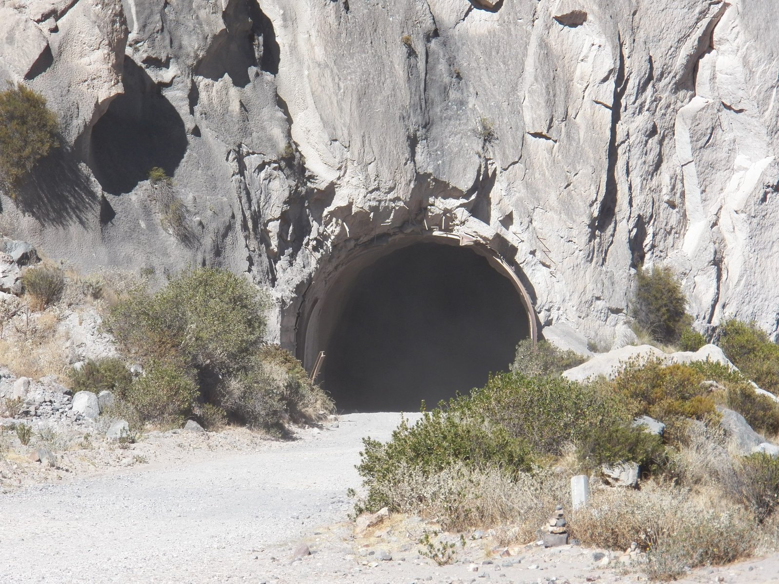 Rond tunnelgat in rotswand.