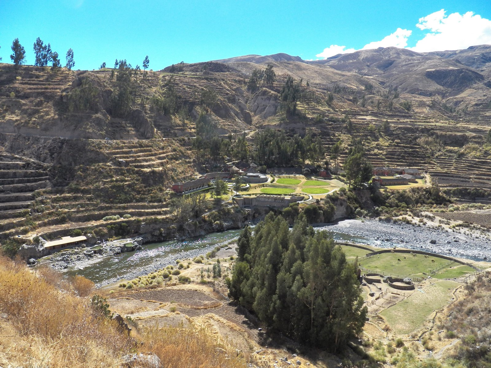 Vallei met terrassen en rivier.