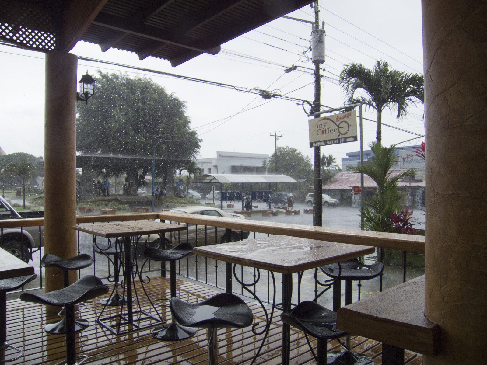Gietende regen gezien vanaf terras van café.