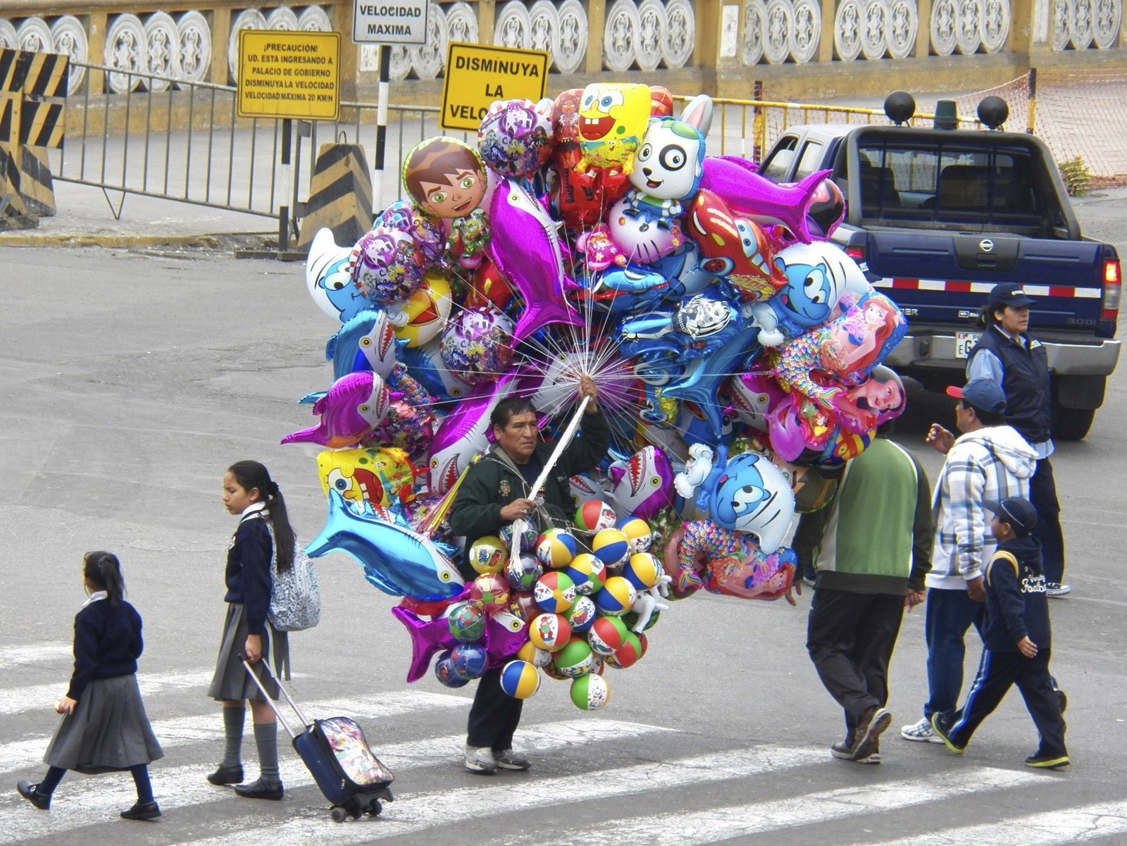 Verkopen van grote kleurrijke ballons op straat.