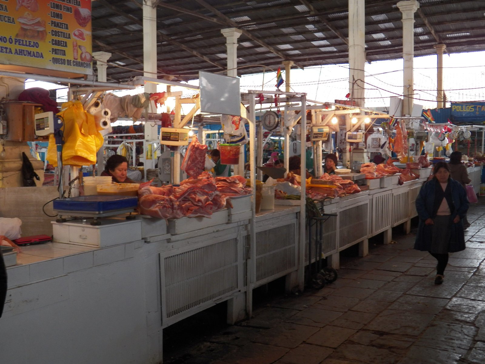 Overdekte markt: kraampjes met uitgestalde grote brokken vlees.