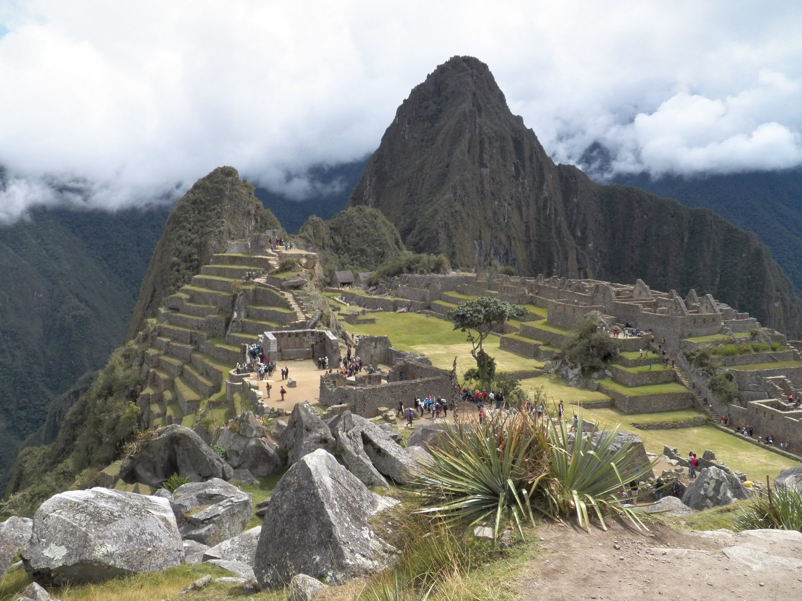 Iconische foto van Machu Picchu met witte wolken in achtergrond.