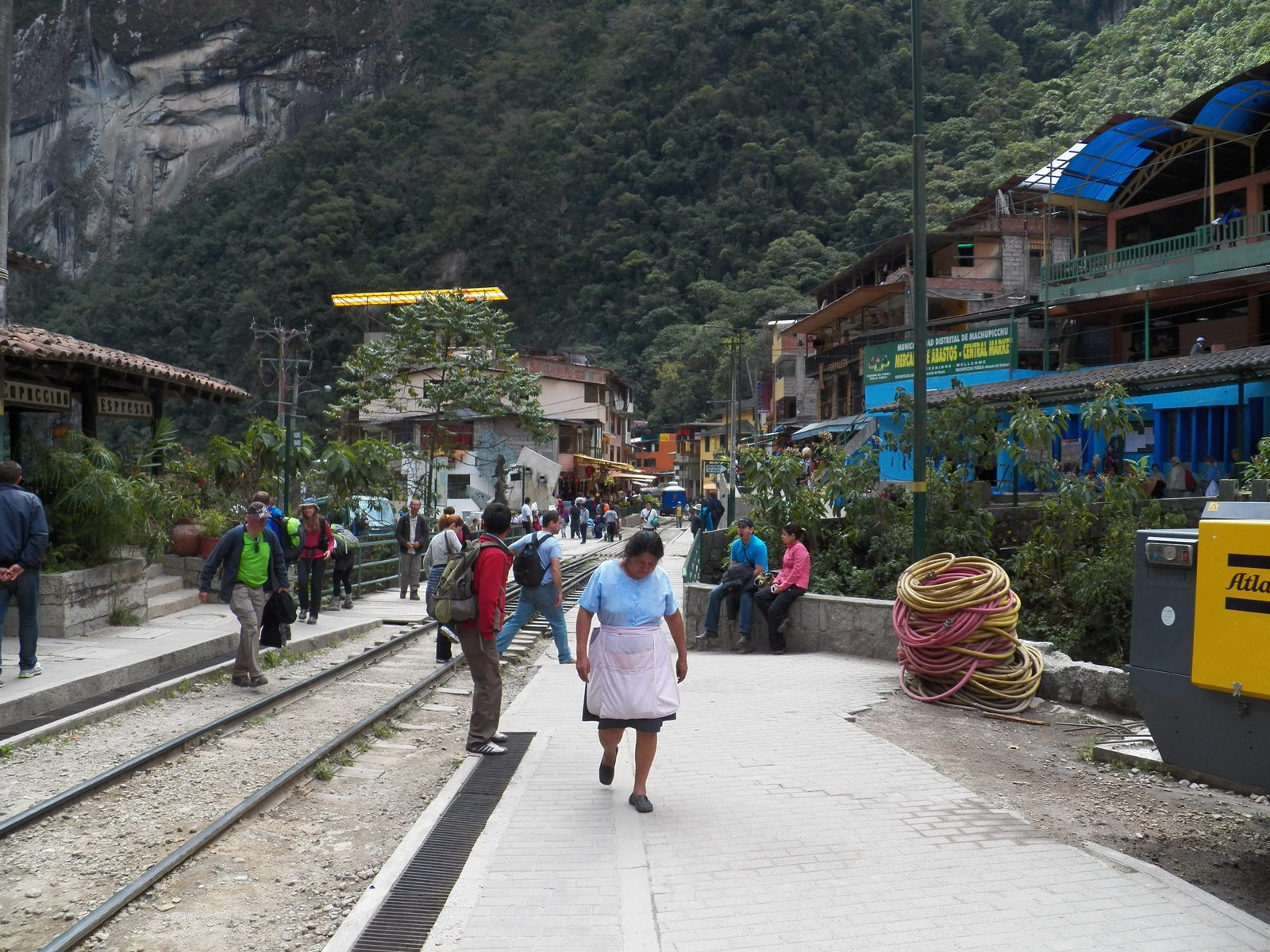Treinstation van Aguas Calientes met ensen die over de sporen lopen.