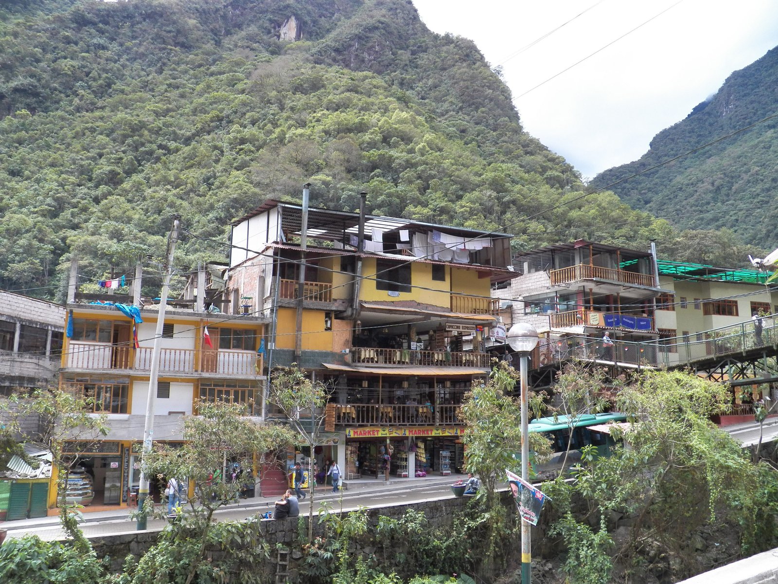 Vijf verdiepingen hoog krotwoningen tegen berghelling in Aguas Calientes.