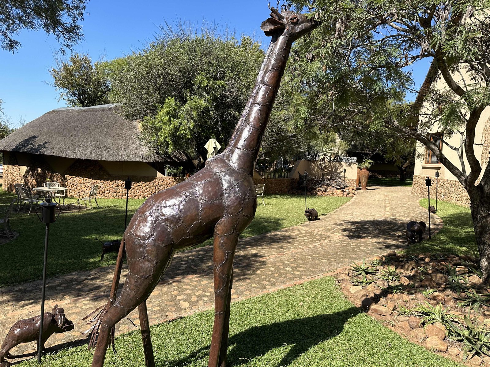 Ukutula Lodge: bruin-metalen giraf voor huis met rieten dak. 