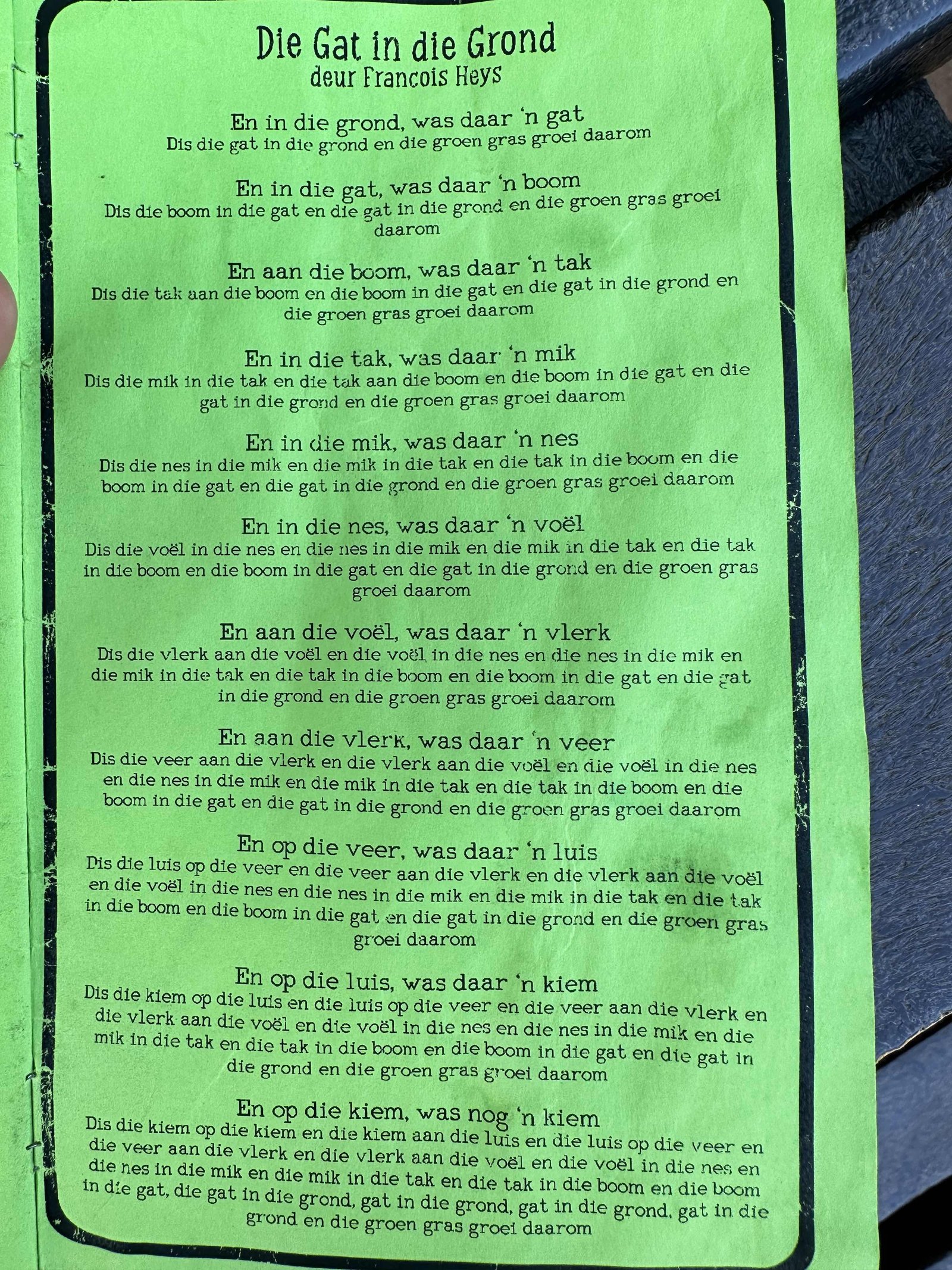 Die gat in die Grond; groene affiche met de tekst van het kinderliedje. 