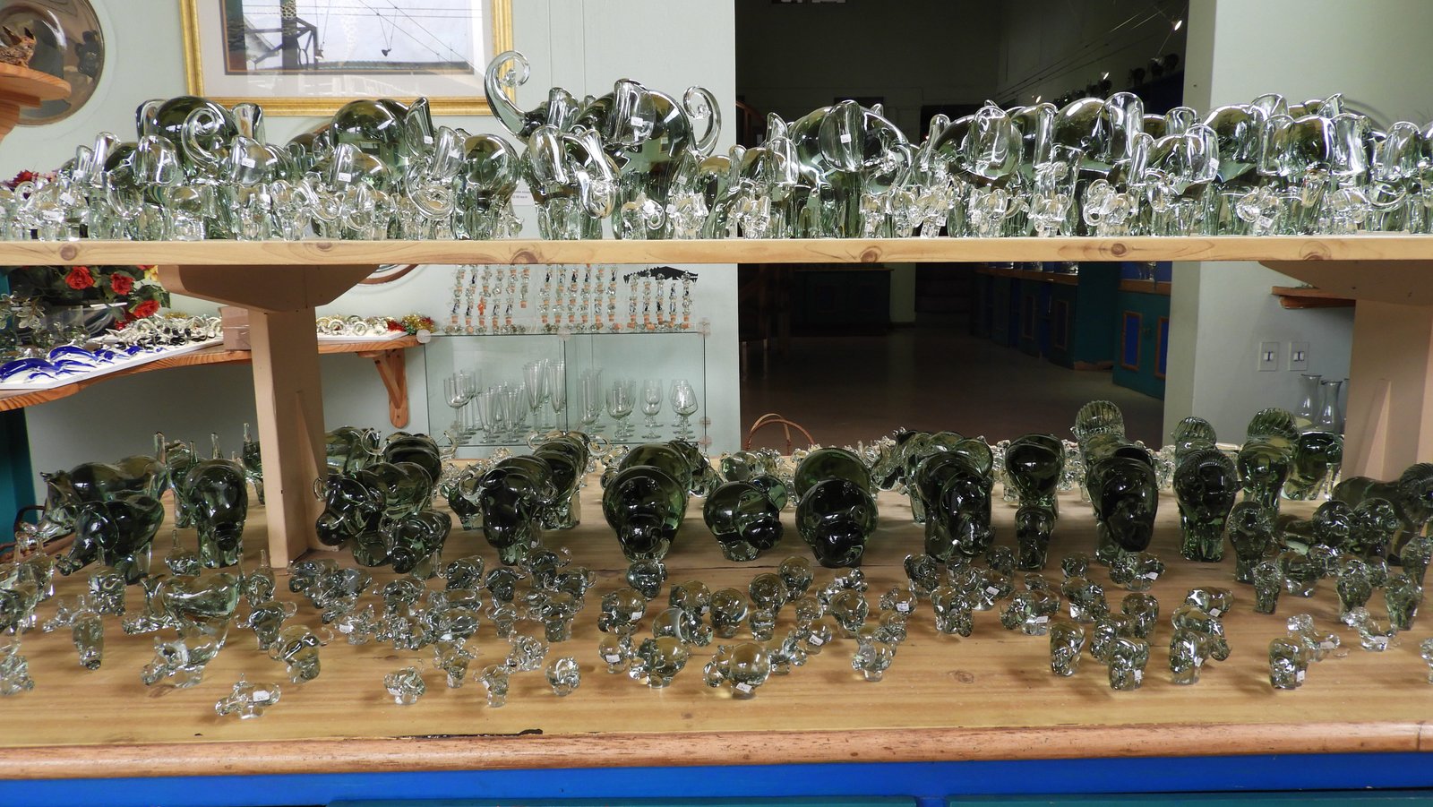 Grote en kleine galzen figuurtjes uitgestald op houten rek.