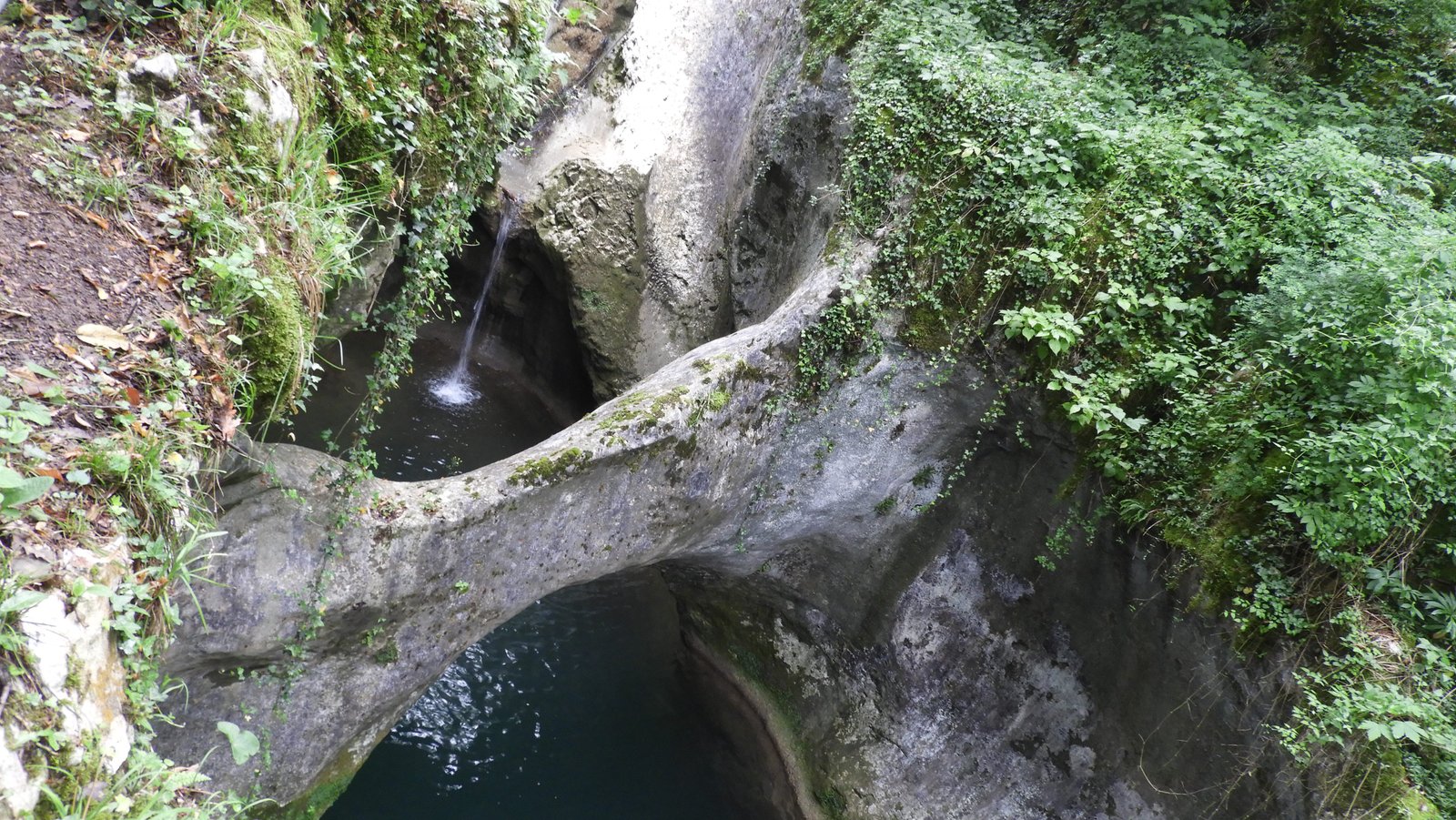 Kloof in kerstgebergte met natuurlijk brug en watervalletje.