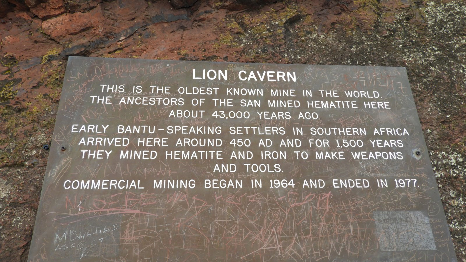 Grijs stenen plakkat met witte letters: uitleg over de Lion Cavern.