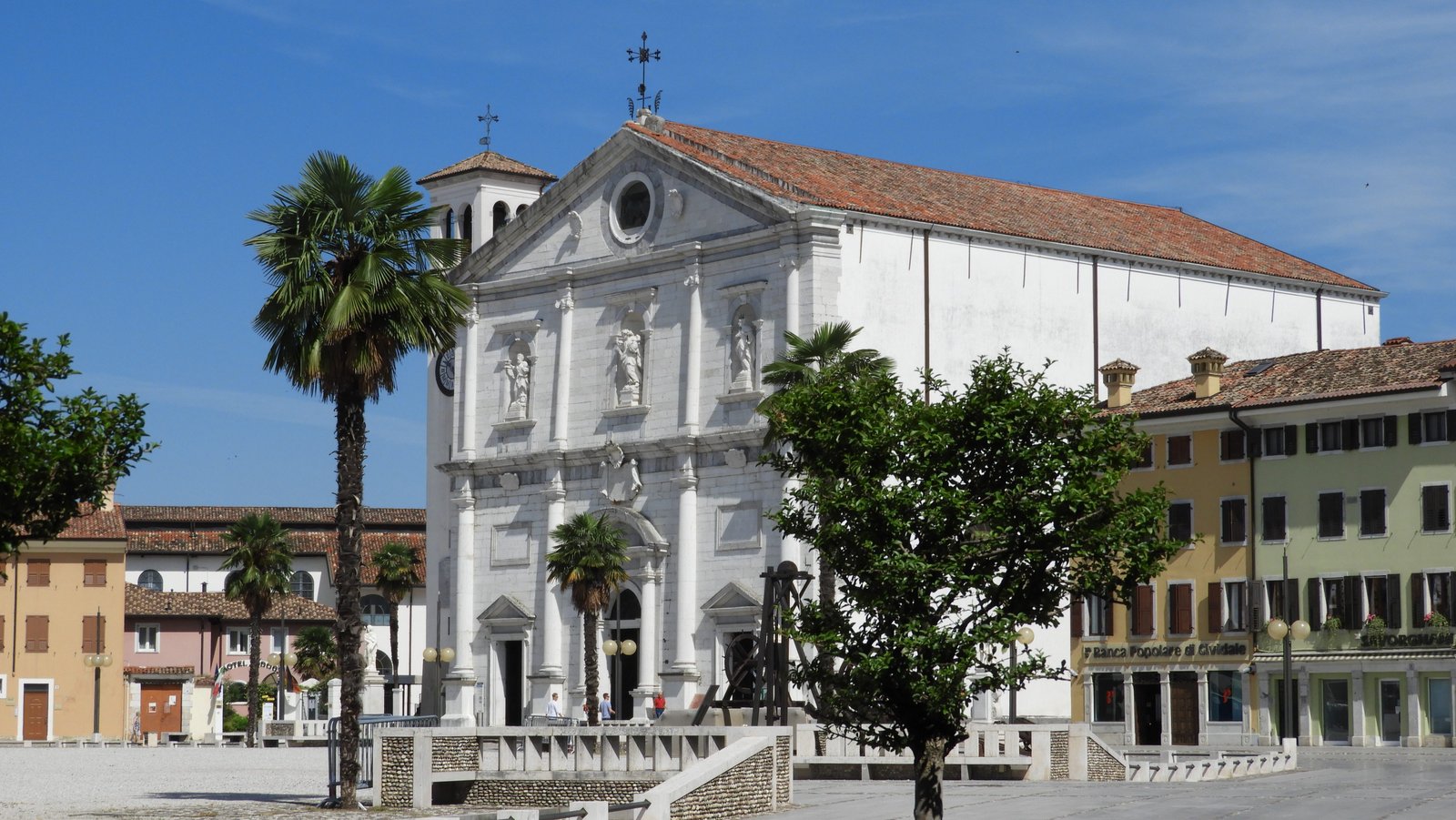 Chiesa dell Santissimo Redentore: witte kathedraal met rood pannendak en palmboom.