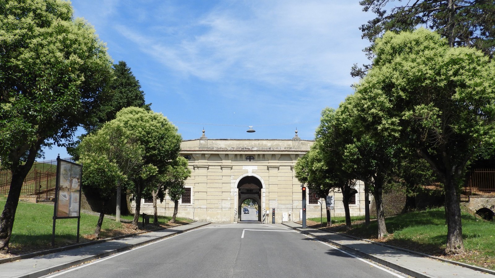 Porta Udine: smalle toegangspoort in lichtgele stadsmuur.