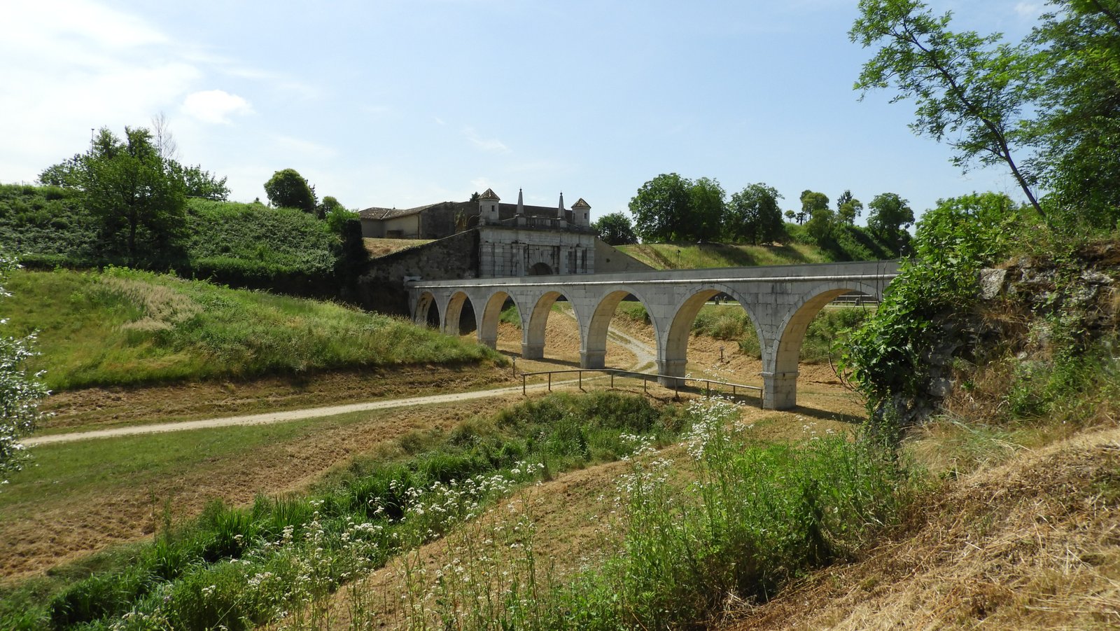 Panorama over bebloede brede gracht rond Palmanova met het aquaduct.