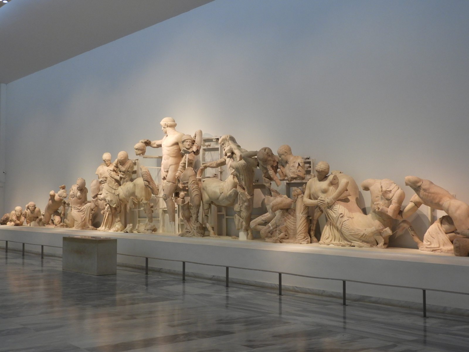 Lange witte beeldengroep in het Archeologisch Museum van Olympia.