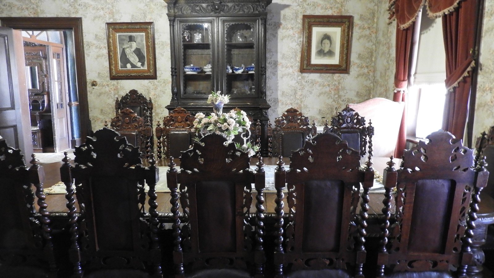 Eetkamer Paul Kruger huis met zware gesculteerde stoelen.
