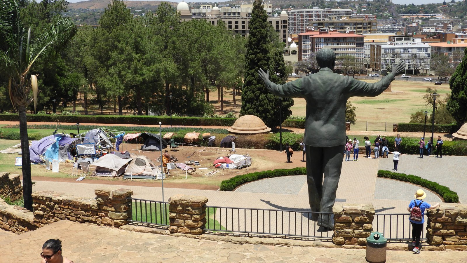 Tentjes van Khoi en San protesterend. Rechts standbeeld van Mandela.