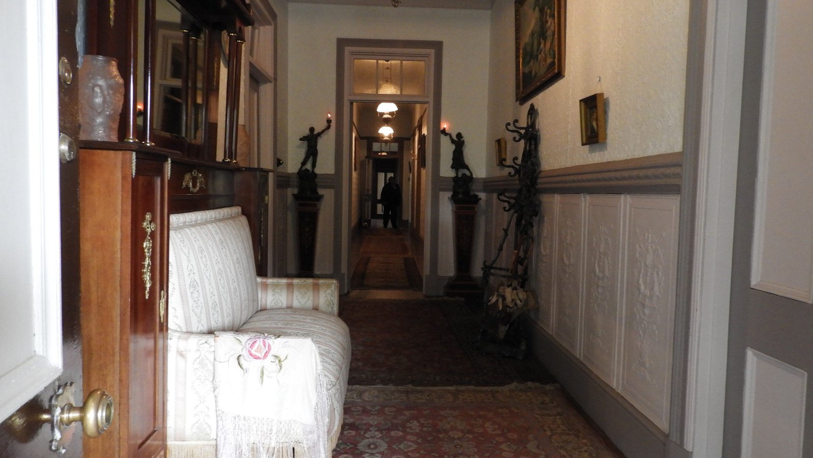Lange, smalle gang in Belhaven House met witte zetel links.