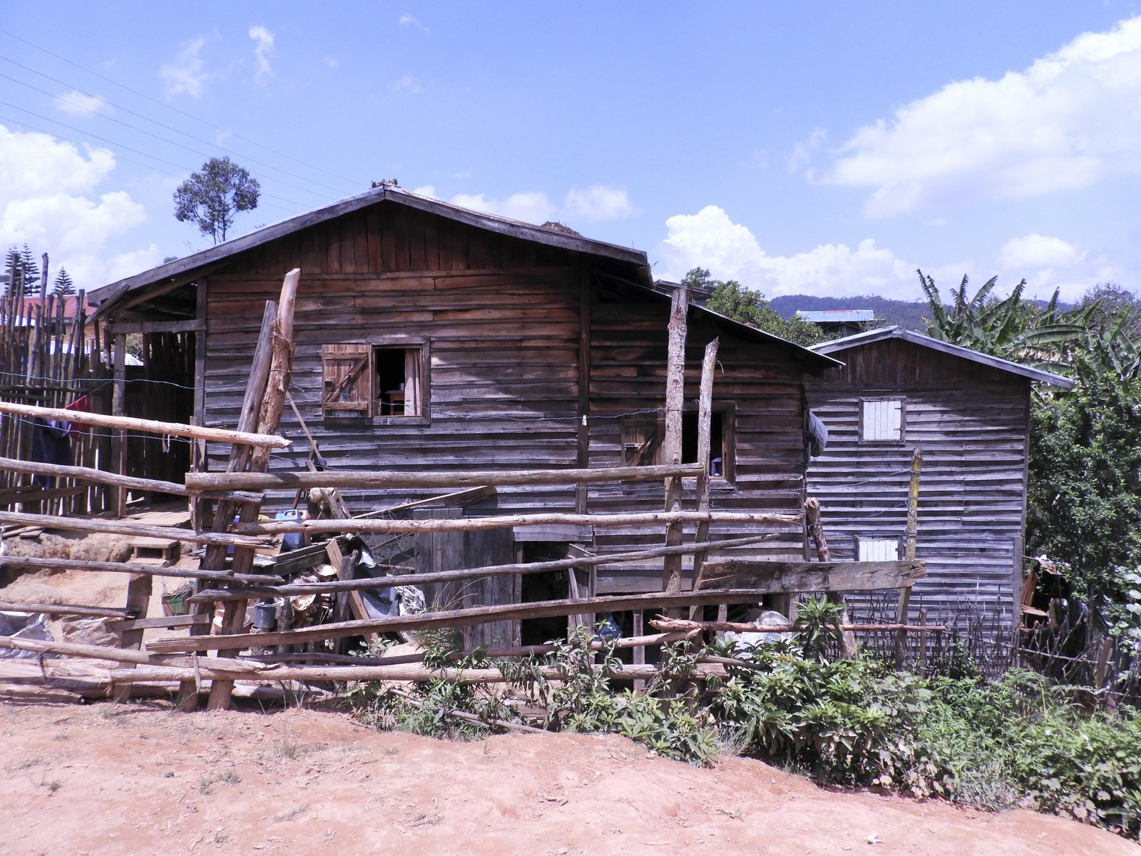 Buiten huis met houten omheining in Andasibe.