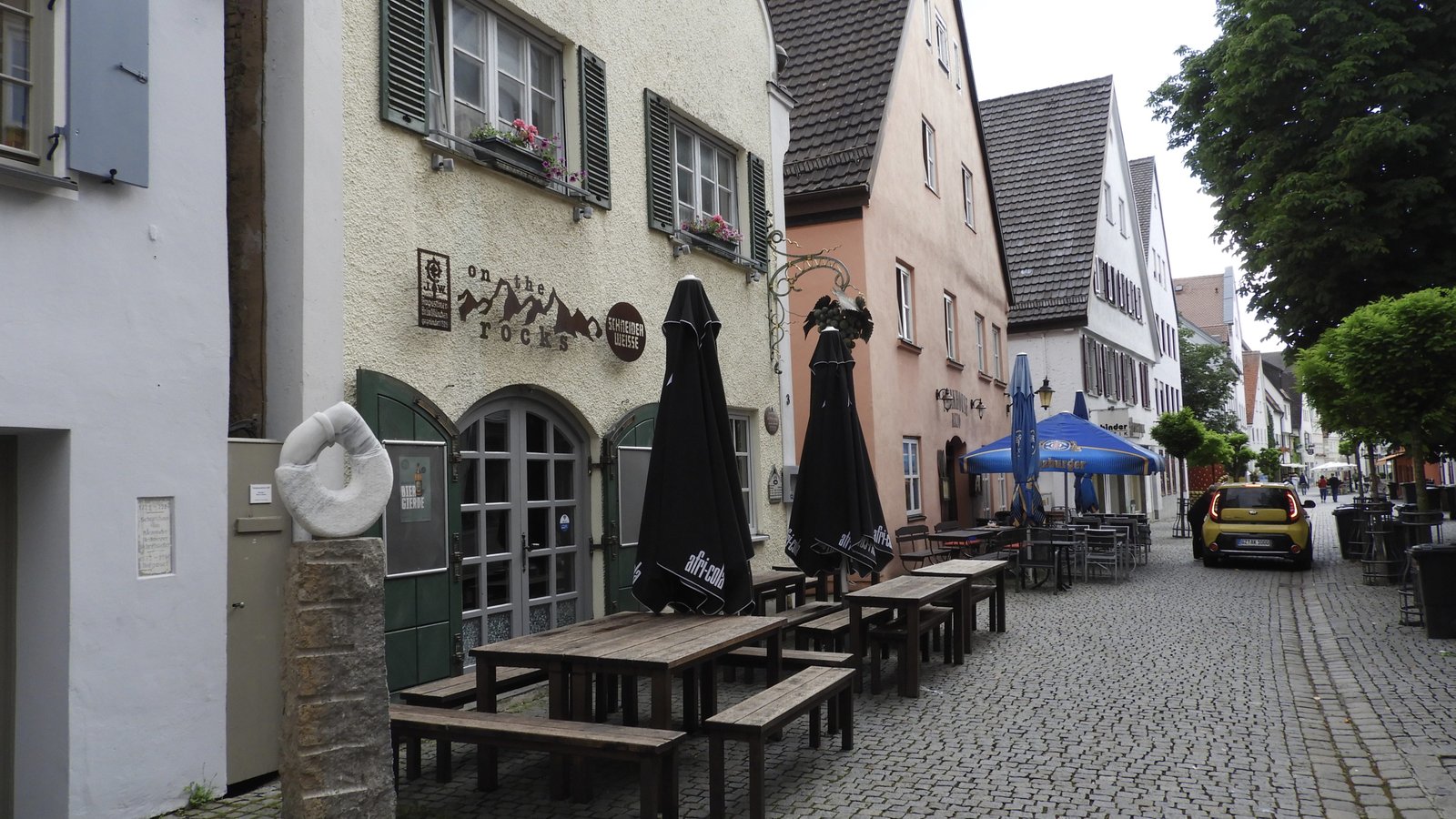 Straat in Günzburg met beige, roze e, Witte Huis; allemaal bars.