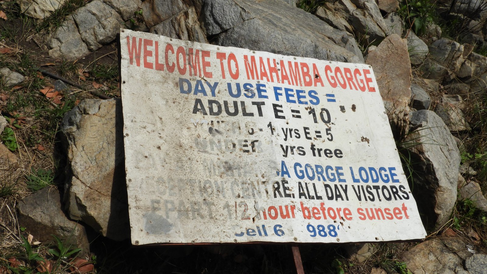 Oud, wit bord met in rode letters: "Welcome to Mahamba Gorge".