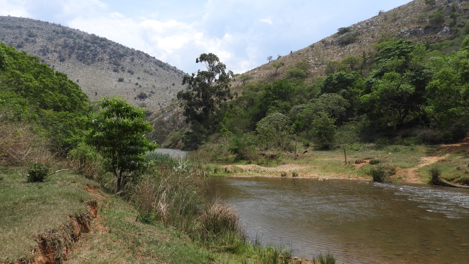Mahamba-kloof: water, groene oevers en kale bergtoppen.