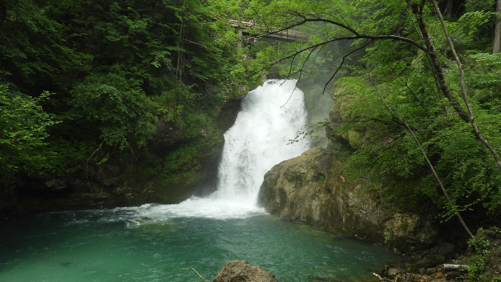 Brede, wilde waterval in bos.
