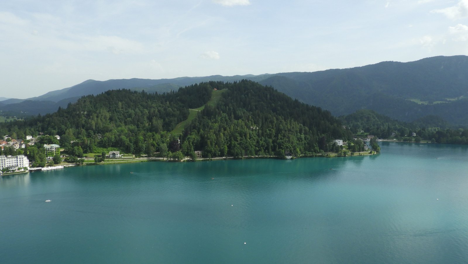 Diepblauw meer van Bohinj met groene berg.