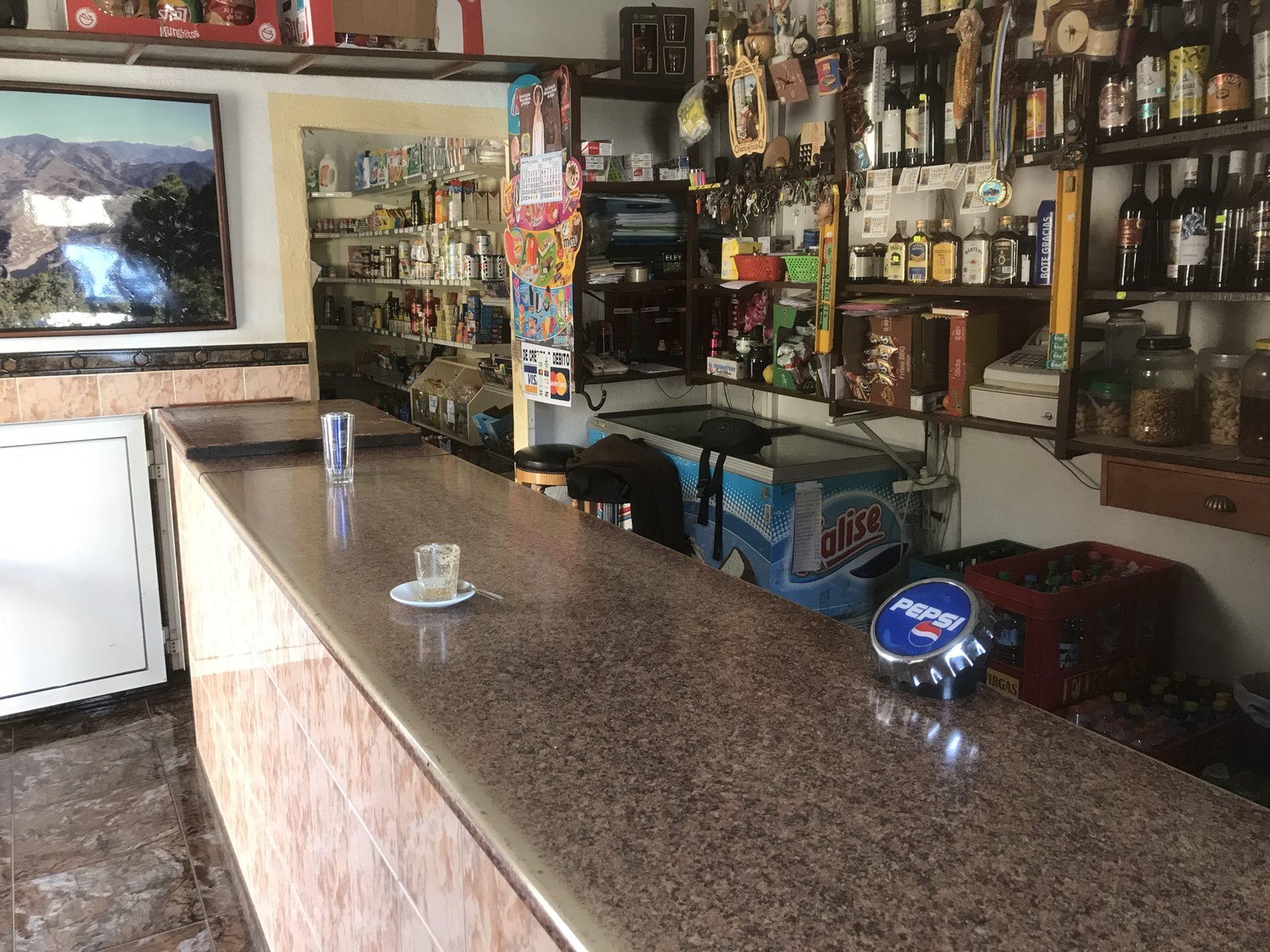 Toog van bar en barkast vol flessen.
