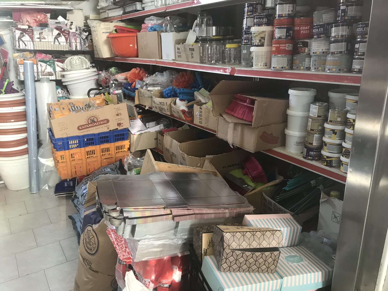 Potten, zakken, dozen, bokalen ... ordeloos gestapeld in gang van supermarktje.