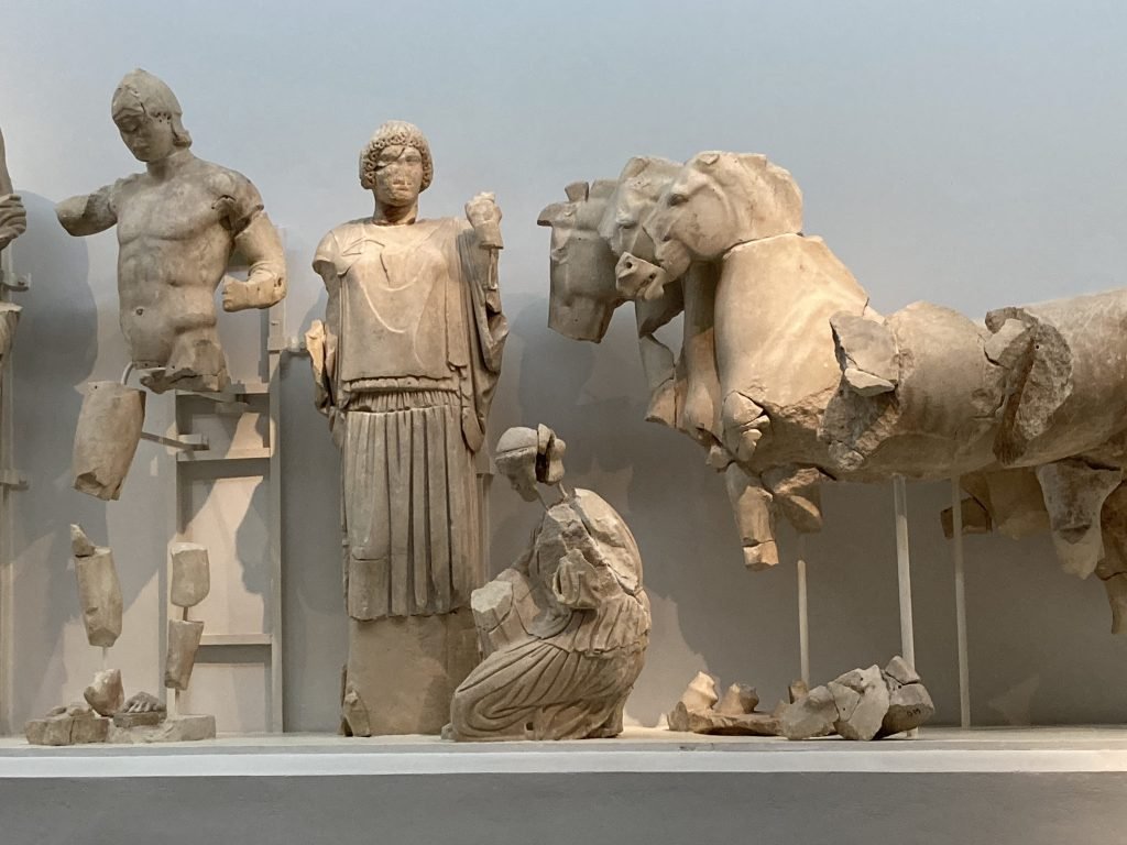 Gereconstrueerde beeldengroep met paarden rechts en menselijke figuren links.