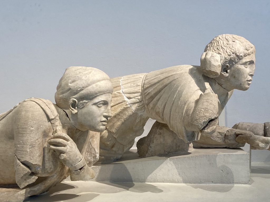 Beeld van twee op hun buik liggende figuren