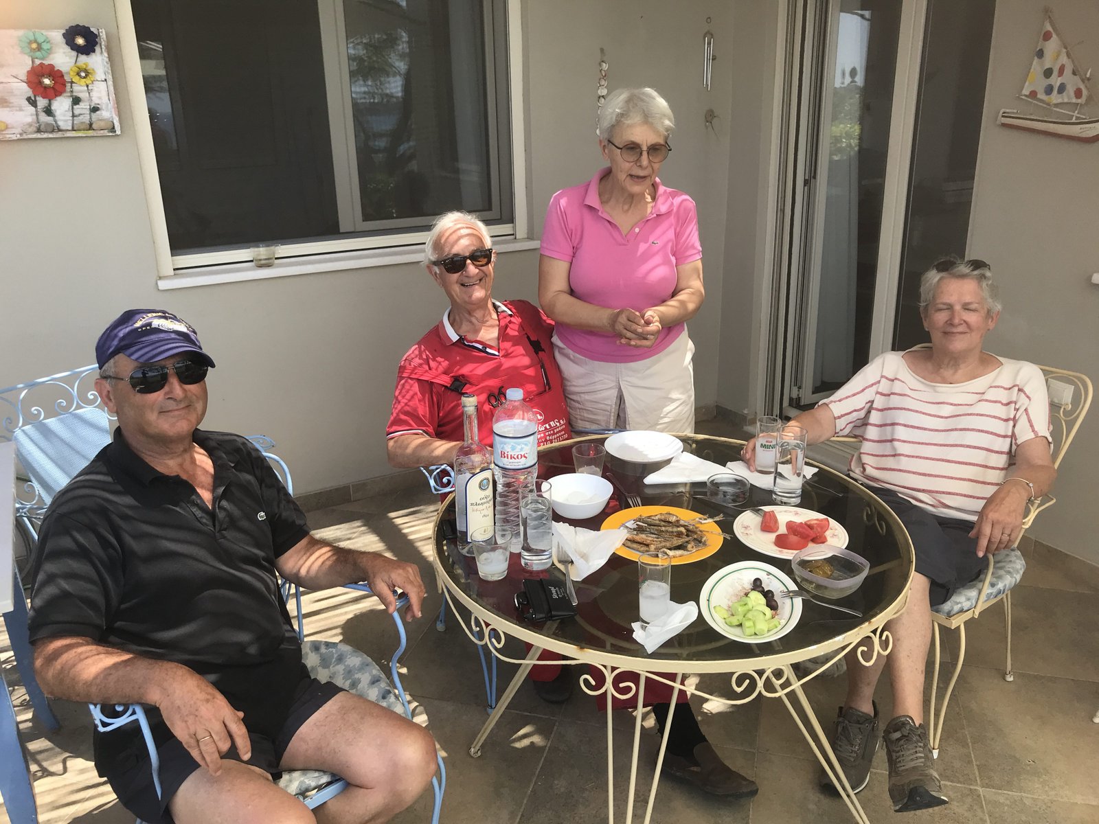 Drie Grieken en een toeriste aperitieven met sardientjes, visjes, tomaten ...