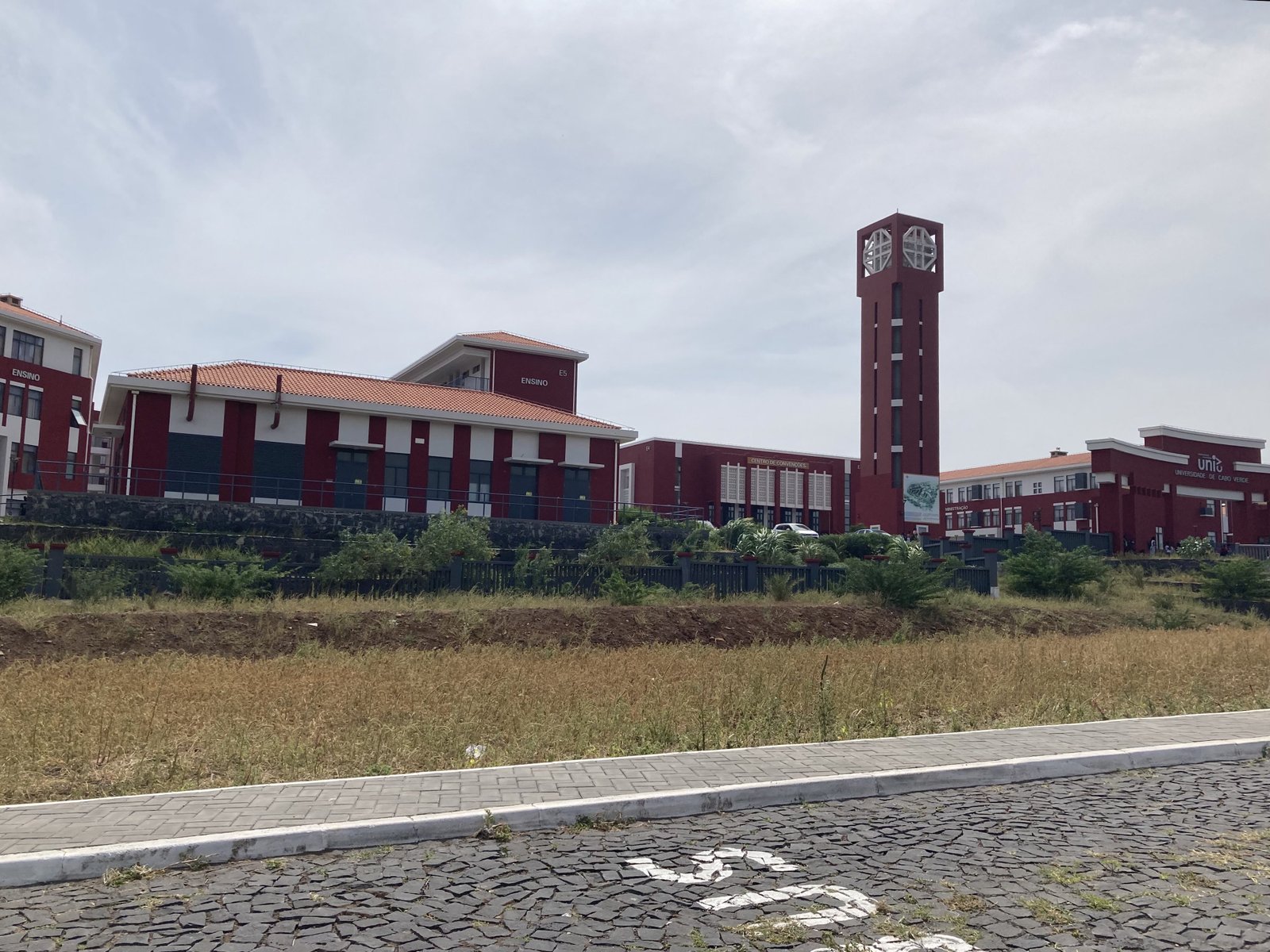 Oker-rode gebouwen van de door China gebouwde universiteit met toren rechts.