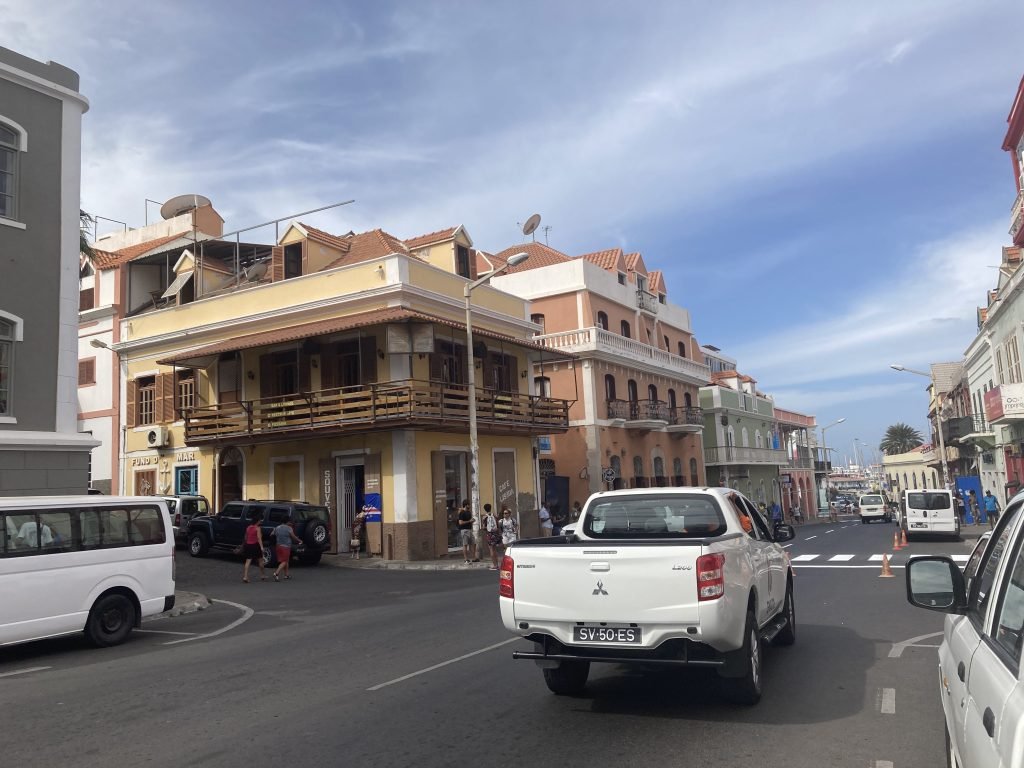 Straat in Mindelo met witte truck en koloniale-stijl huizen.