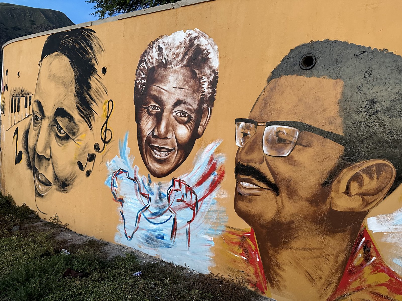 Muurschildering van onder andere Cesária Évora en twee andere figuren.