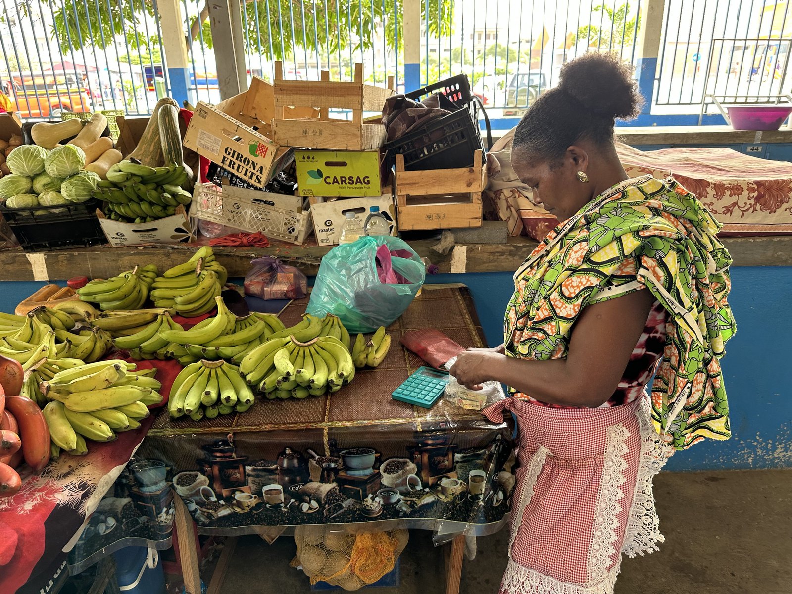 Kleurrijk geklede vrouw verkoopt bananen in Tarrafal.