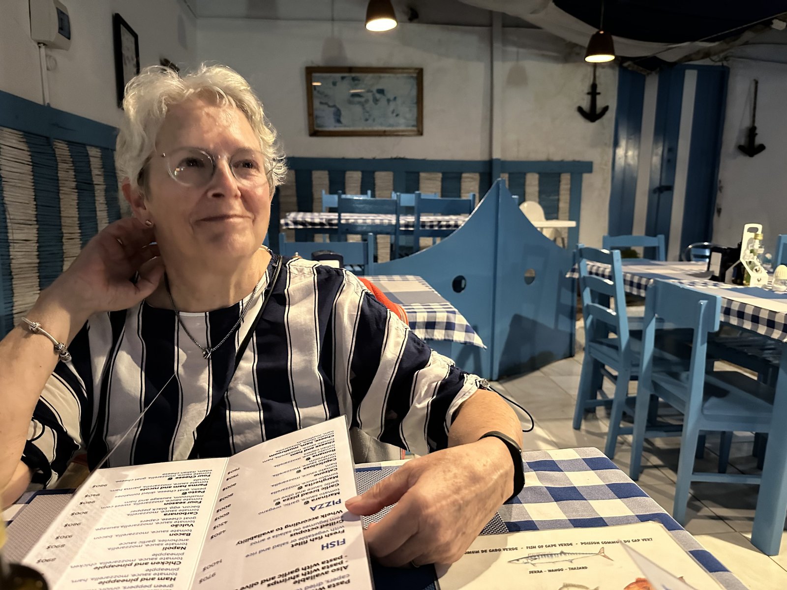 Toeriste met menukaart in blauw interieur van restaurant Alta Mira.